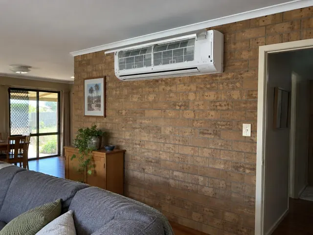 Clean split system on a brick interior wall with open front panel and visible filters in Gilles Plains